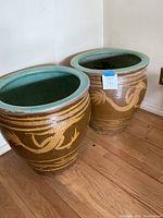 Two Asian-style ceramic planters, brown with green rims and gold dragon motifs, shown side by side.