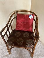 Full view of bentwood chair with red cushions on seat and backrest, showing overall style and materials.