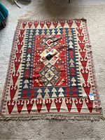 Full view of Kilim rug showing overall geometric pattern and fringe ends.
