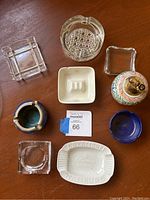 Top-down view of the smoking set including eight ashtrays and one table lighter on a wooden surface.