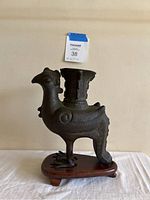 Front view of the vintage Chinese ceremonial vessel shaped like a bird showing overall form and mounted wooden base.