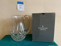 Waterford Crystal clear pitcher with Lismore pattern next to its original box.