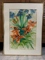 Framed floral watercolour art showing the full composition of orange and blue flowers with green leaves.