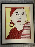Full view of the framed cubist painting of a lady wearing a red headscarf, red earring, and patterned clothing against a yellow background.