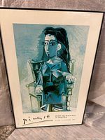 Full view of framed Picasso lithograph showing cubist styled woman seated, signed at bottom with museum and exhibition info.