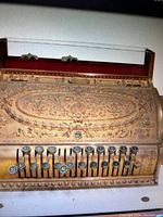 Top and front view showing embossed brass cover and manual keyed button panel