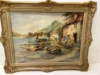 Full view of the framed watercolour painting showing river shore with boats and houses.