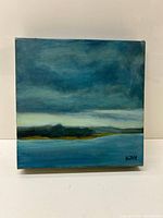 Frontal view of the small 8x8 inch square painting showing a water landscape with cloudy sky and signature KW in lower right.