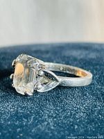 Close-up side view of sterling silver ring with large clear rectangular clear stone held by prong setting, showing the 'Espo' signature stamp inside the band.