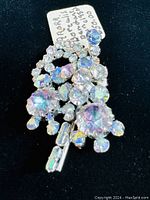 Vintage 1950's aurora borealis rhinestone pin pendant, showing front view with multifaceted stones displaying iridescent colors on silver-tone setting.