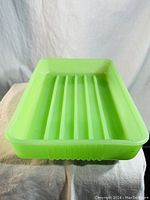 Front angle view of vintage Fenton Jadeite glass baking dish showing ribbed bottom and green opaque glass material.
