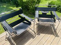 Both chairs on wooden deck outdoors, full view