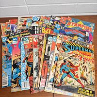 Lot of 30 vintage comics fanned out showing various titles and covers including Superman, Starfire, Batman, Wonder Woman, Justice League.