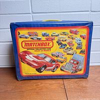 Official blue Matchbox collector case with colorful label showing images of vintage Matchbox cars and trucks, stating it holds 48 models.