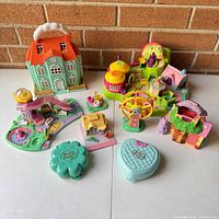 Overview of all six Polly Pocket playsets and compacts arranged on table