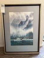 Framed art print above floor with tag, showing full scene of sailboat in misty mountains.