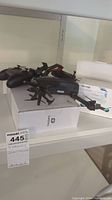Shelf display showing black foldable drone on D70 box and two controllers