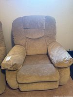 Front view of tan La-Z-Boy padded reclining rocker chair showing cushioned seat, back, and armrests.