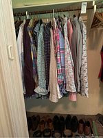 Closet rod with 16 hanging long-sleeve dress shirts in various patterns