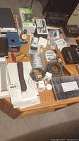 Overview of table with assorted watches, straps, chargers, O-ring kit and other accessories