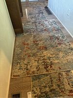 Full view of two runner rugs laid out on wood floor, showing abstract multicolor pattern.