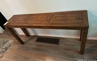 Side view showing the full length and leg design of the wooden sofa table with geometric inlay pattern on tabletop.
