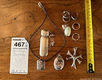 Overall view of all jewelry pieces on wooden table with ruler