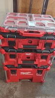 Front view of stacked Milwaukee Packout units: organizer, two toolboxes, and rolling caddy