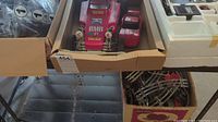 Box containing large pink/red off-road RC buggy and smaller red Corvette RC car body, viewed from above