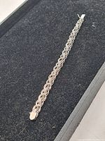 Full view of the sterling silver bracelet on a black surface.