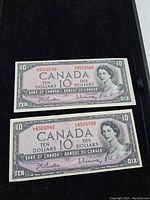 Front view of two 1954 Series Canada ten dollar bills showing Queen Elizabeth II portraits and serial numbers.