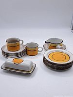 Full set showing cups, plates, creamer, butter dish arranged on white background.