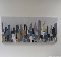 Frontal view of the rectangular abstract modern cityscape painting showing the skyline with various color blocks and building shapes.