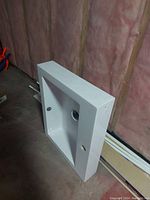 Side view of the white ceramic bathroom sink showing thickness and flat back side.