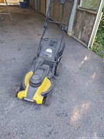 Front and top view of the black and yellow Worx electric lawn mower showing the motor housing, control lever, and folded handle.