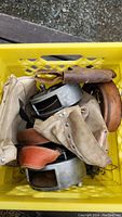 Top view of yellow crate containing various tool belts, pouches and wire reels.