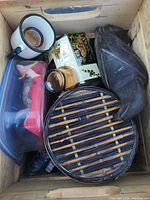 Top view photo showing mix of items including mug, brass shaver, bamboo round box, and black shoe decor.