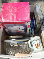 Photo of boxed elephant cookie jar along with glass ashtray, white ceramic plate, and two metal flatware cases.