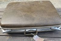 Closed brown Samsonite suitcase showing textured exterior and metal handle