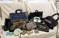 Image showing a large assortment of vintage purses and bags including a prominent blue leather attache case and green bowling bag in the background.