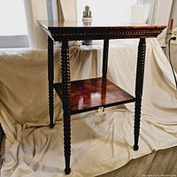 Full angled view of vintage French spindle side table showing twisted legs, top, and shelf.