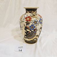Full view of the vase showing a female figure, bird, and floral decoration on cream background with gold gilt accents.