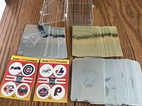 Four hologram baseball cards laid out with two sheets of team logo stickers next to them.