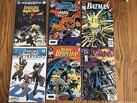 Six Batman themed comic books arranged in two rows of three, showing various cover artworks including Batgirl and Batman in action poses, vibrant colors.