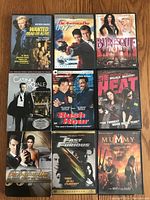 Photo showing nine DVD cases arranged in three rows of three including Wanted: Dead or Alive, Die Another Day, Burlesque, Casino Royale, Rush Hour, Heat, Die Another Day James Bond Edition, Fast and the Furious, and The Mummy Tomb of the Dragon Emperor.