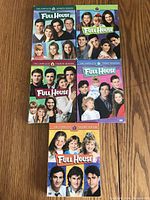 Top view of five Full House DVD season sets arranged in a grid showing front covers with cast photos and season numbers.