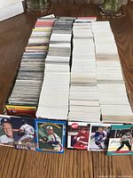 Large box of hockey and baseball cards arranged in stacks with some cards visible showing players and logos.