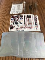 Top view of hologram hockey player cards with a clear plastic protective case and card sleeves on a wooden surface