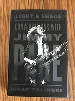 Front cover of the hardcover book 'Light & Shade: Conversations with Jimmy Page' showing black and white photo of Jimmy Page with guitar