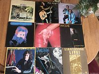 Top view showing 9 LP vinyl records on a wooden table with minor scratches or light scuffs on covers.